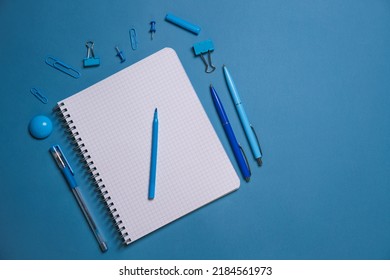 Stationery. Open Notebook Pencils And Pens, Stickers And Binding Clips. Copy Space And Notes. Writing Tools. Office Tools. Isolated On Blue Background