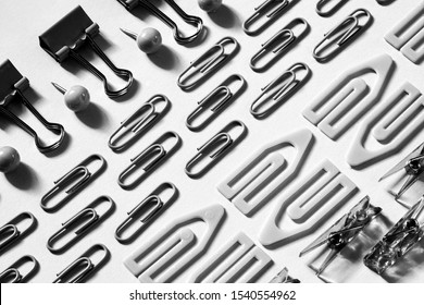 stationery pattern, paper clips neatly laid out, the concept of perfectionism and order, black and white photo
