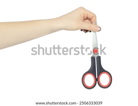 stationery scissors in hand, outstretched hand with scissors isolated from background
