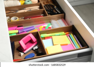 Stationery and sewing accessories in open desk drawer indoors, closeup