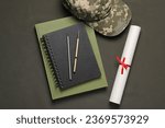 Stationery, soldier cap and diploma on dark background, flat lay. Military education