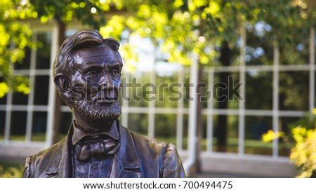 Statue of Abraham Lincoln Sitting With Green Blurry Leaf Bokeh And White Window Frame In Background, Gettysburg Battlefield, Pennsylvania, United State