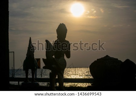 The statue adorns the temple on an island lake on the day of the sunset Silhouette.