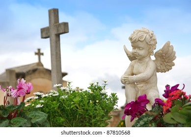 Statue Of An Angel Boy Located In A Cemetery