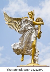 Statue Of Angel Holding A Bouquet Of Flowers.