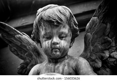 Statue Of A Baby Angel On The Graveyard