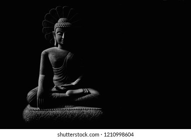 Statue of Buddha sitting in meditation with black space on the left hand side
