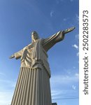 Statue of Christ the Redeemer, copy of Brazilian sculpture. Monument to Jesus Christ, architectural monument. Concrete sculpture of the Son of God, arms outstretched.