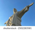 Statue of Christ the Redeemer, copy of Brazilian sculpture. Monument to Jesus Christ, architectural monument. Concrete sculpture of the Son of God, arms outstretched.