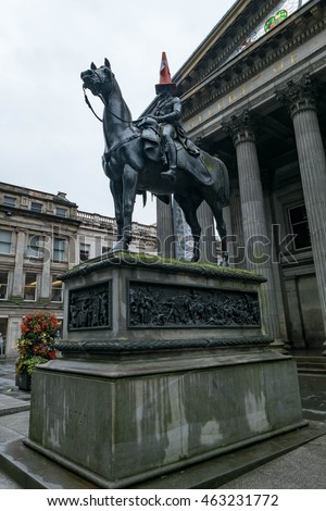 Statue of Duke of Wellington, riding a horse, wearing a traffic cone on his head. In front of Gallery of Modern Art, Royal Exchange Square, Glasgow, Scotland.