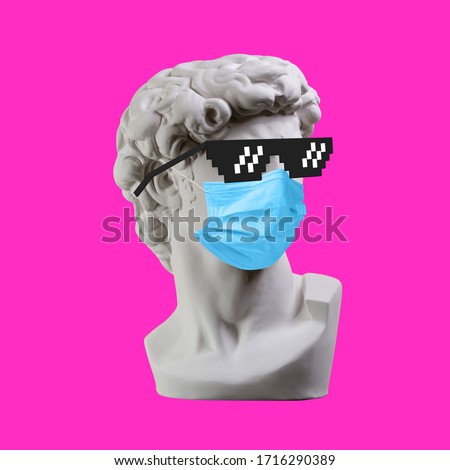 Statue. Earphone. Isolated. Gypsum statue of David's head. Man. Creative. Plaster statue of David's head in pixel glasses and medical mask. Minimal concept art.