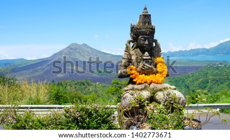 Statue in the foreground with Kintamani volcano mountain in the background at Bali Indonesia
