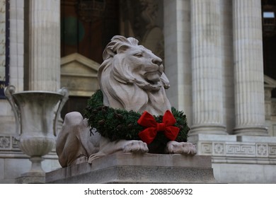 The statue of Fortitude the lion wears a mask and Christmas wreath around its neck in front of the majestic Beaux-Arts building at Fifth Avenue in New York City. (Photo: Gordon Donovan)
 - Shutterstock ID 2088506932
