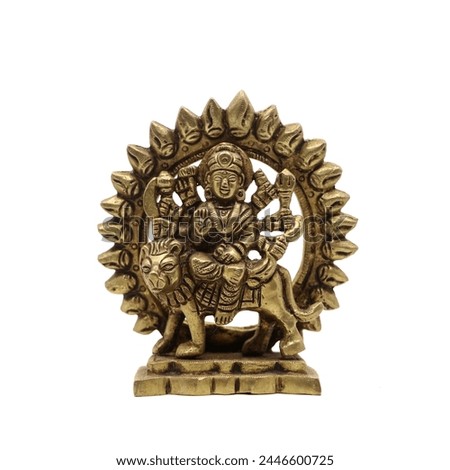 statue of goddess durga devi of hindu religion holding multiple weapons in her many arms, sitting on her lion, handcrafted with details in golden brass isolated in a white background
