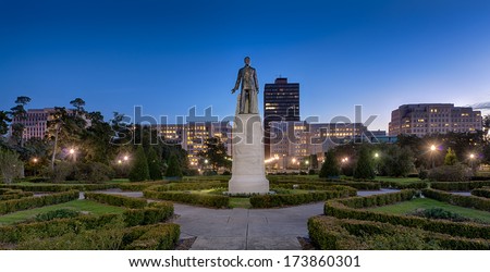 Statue and grave site of Huey Long on the grounds of the Louisiana State Capitol building at night in Baton Rouge, Louisiana