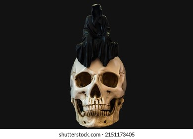 A Statue Of A Grim Reaper Sitting On A Skull.