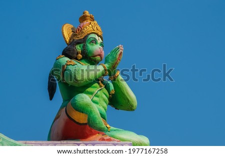 Statue of Hindu God lord Hanuman on the top of the temple; green statue of god Hanuman; Lord Hanuman doing namaste statue.