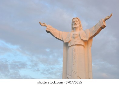 Statue of Jesus Christ with open arms at sunset