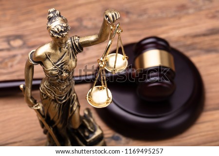 Statue Of Justice With Brown Gavel On Wooden Table