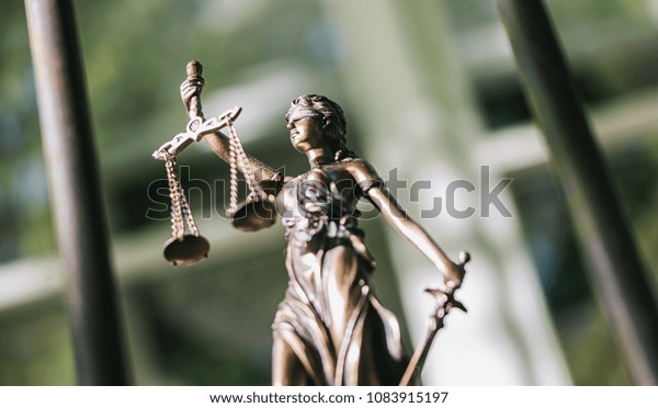 The Statue of Justice - lady justice or Iustitia /\
Justitia the Roman goddess of Justice against a prison grid, legal\
law concept image
