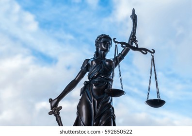 Statue of Justice symbol with cloudy sky background - Powered by Shutterstock