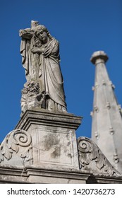 Statue Of Lady Hugging Cross At Cemetery	