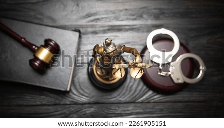  Statue of Lady Justice, handcuffs, book and gavel.