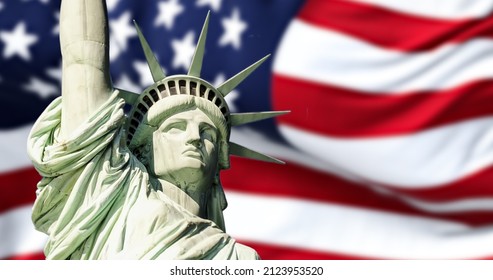 the statue of liberty with blurred american flag waving in the background. Democracy and freedom concept.