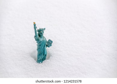 Statue Of Liberty Miniature In The Snow. Winter Snowfall In New York Concept 