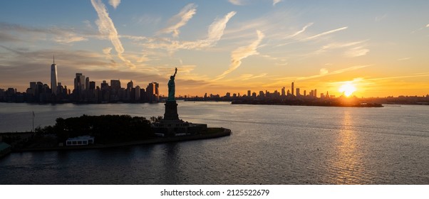 The Statue Of Liberty And New York City At Sunrise.