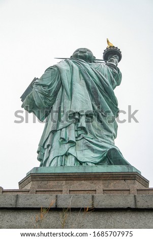 Statue of Liberty in New York City seen from the Back with a white Background, during a cloudy day in Fall.