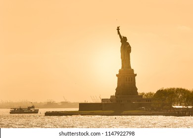 Statue of Liberty silhouette in sunset, New York City, USA.