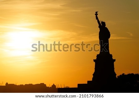 The Statue of Libery baths in golden light as she watches the sun decend.