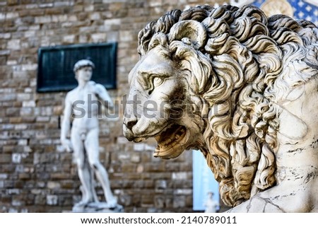 Statue of lion at Loggia Dei Lanzi in front of Florence Palazzo Vecchio and statue of David in Florence, Italy. Architecture and landmark of Florence, postcard of Florence.