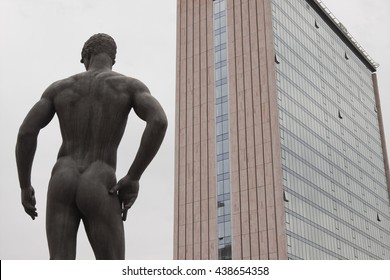 statue of man with skyscraper.