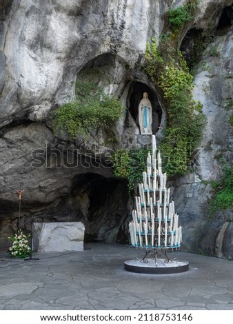 Statue of Our Lady of Immaculate Conception with a rosary in the Grotto of Massabielle in Lourdes, France