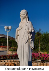 statue of Our Lady of Medjugorje in Bosnia, the Blessed Virgin Mary, against blue sky