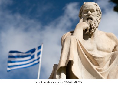 Statue of Socrates in Athens with greek flag on the background.