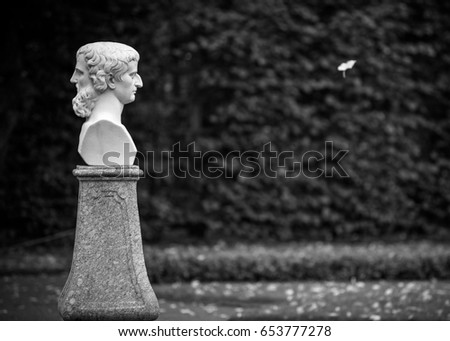 A statue of two-faced Janus, Greek god of time. Black and white photo
