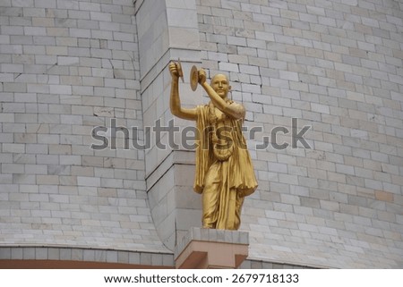 A statue of a Vaishnava devotee on the wall of a temple
