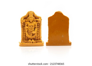 The statue of Venkateswara Swamy carved in brown wood is insulated with white reflection on the front and back.
