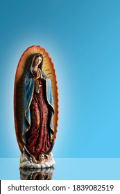 statue of Virgin of Guadalupe isolated on blue background (Use editorial only)