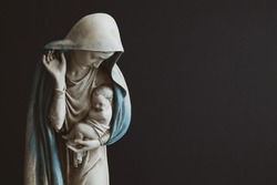 Statue Of Virgin Mary Holding Baby Jesus With A Black Background With Copy Space 