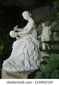 Statue of a woman drawing on a ball and statue of a man watching a woman
