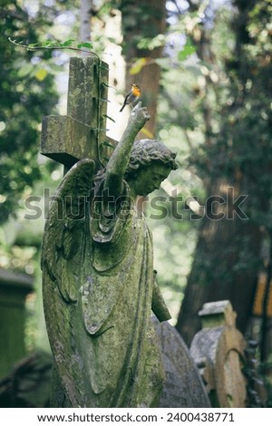 Statue of woman with red robin perched on an outstretched finger, Highgate Cemetery, London, England, United Kingdom, Europe