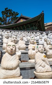 Statues of some of he 500 Buddhaâs Disciples white statues by a temple hall in Bomunsa Temple on the island of Seongmodo, Ganghwa, Incheon, South Korea.Vertical view.