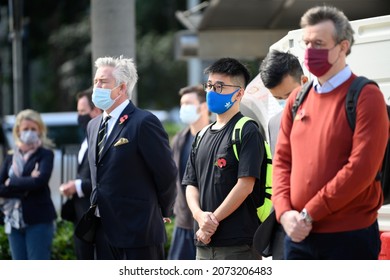 StatueSquare,Central,HongKong-11Nov2021:Remembrance day,Armistice Day,people with mask on face and red poppy flower on body,feeling sad,standing in front of cenotaph,to mourn soldiers died in worldwar