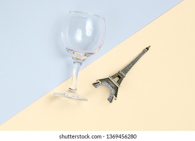 Statuette Of The Empire Tower, Empty Wine Glass On A Gray-yellow Paper Background. Top View, Flat Lay, Minimalism
