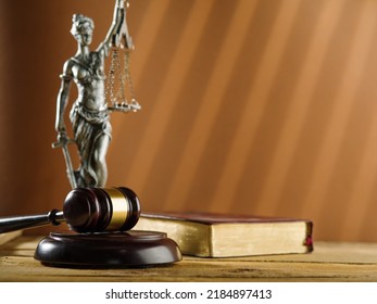 Statuette Of The Goddess Of Justice - Themis, A Wooden Gavel Of A Judge And A Book On A Beige Background. Symbols Of An Honest Fair Trial. Constitution, Bible, Rule Of Law.