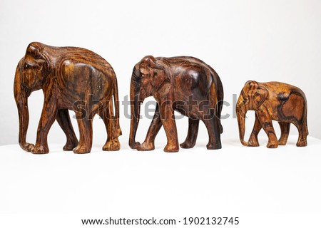 Statuettes of wooden elephants on a white background.